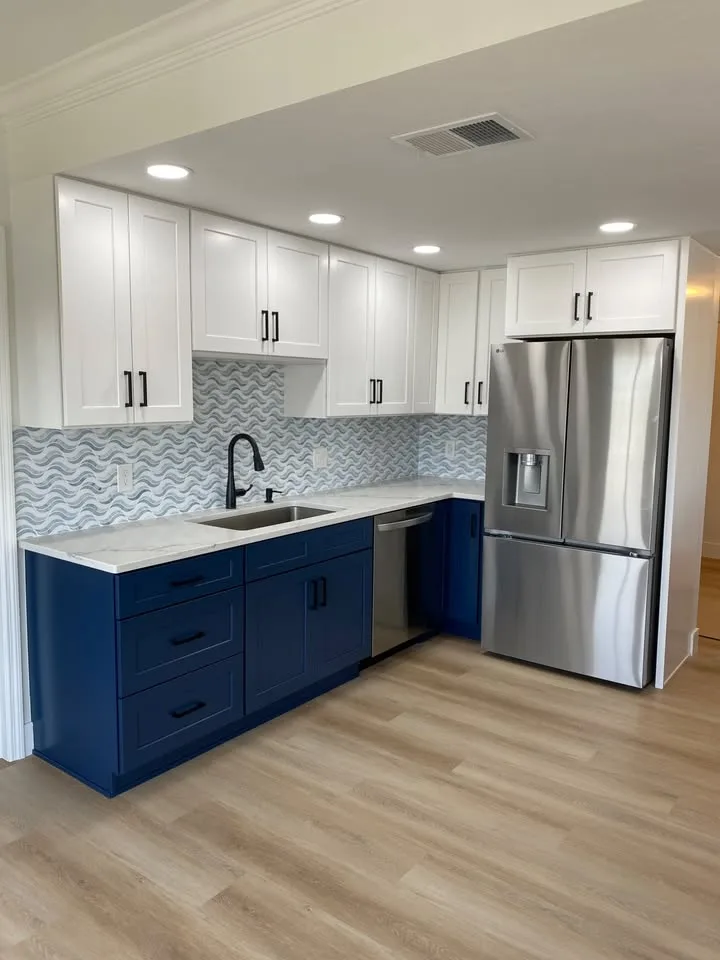 Navy and white shaker kitchen over light oak LVP flooring in a Cape Coral home