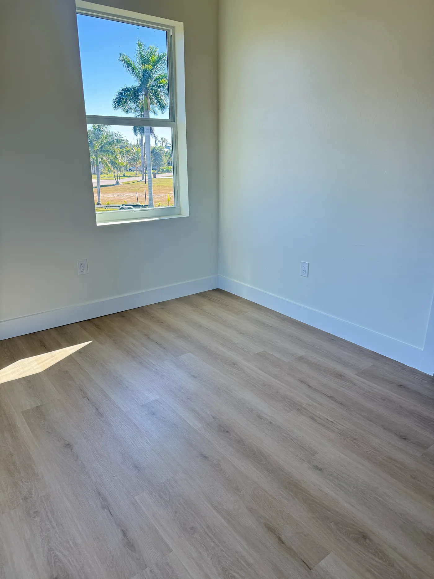 Light oak wide-plank luxury vinyl flooring carried through a bedroom in a whole-home install