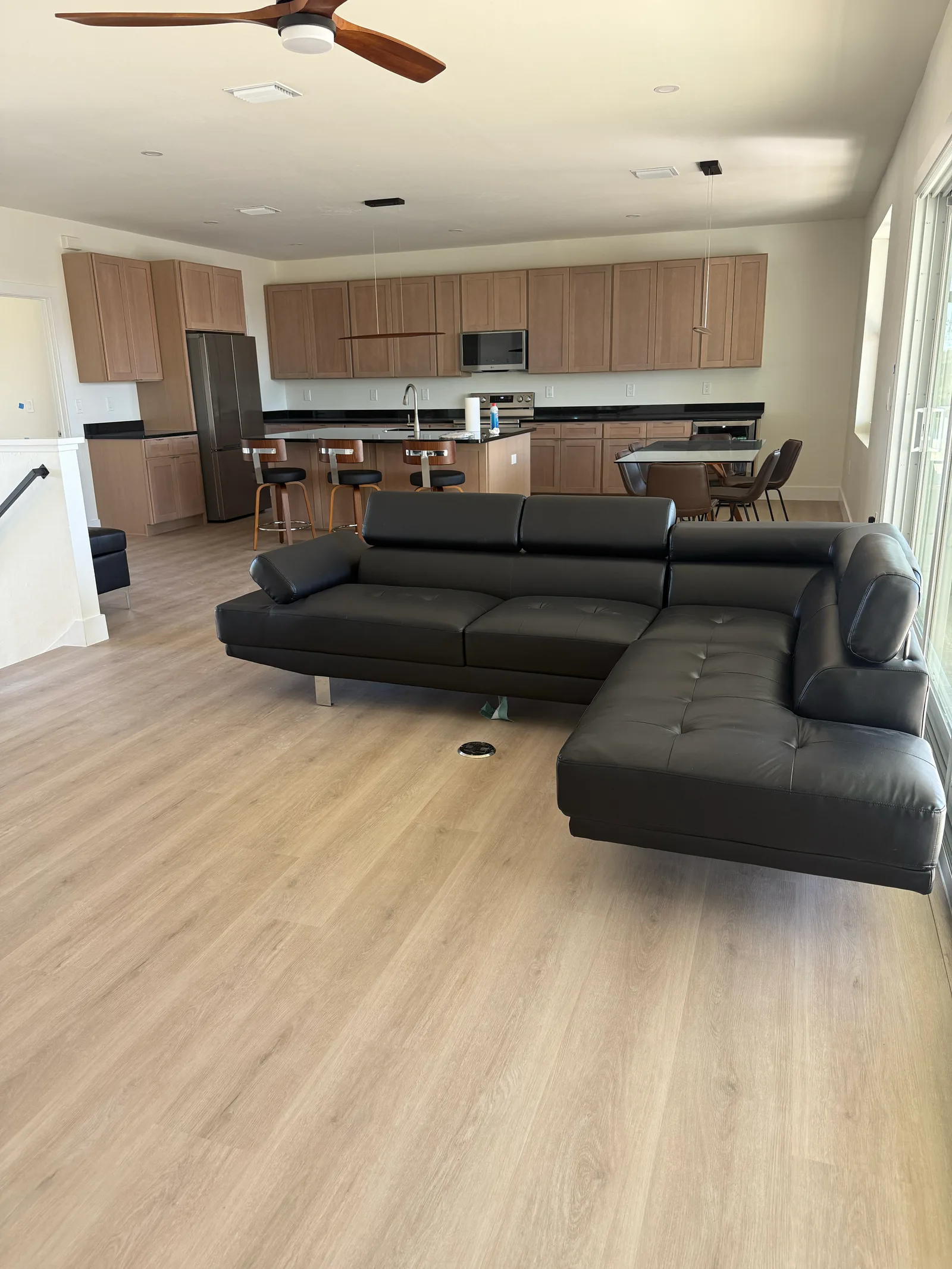 Light oak luxury vinyl plank flooring running through an open-plan living room and kitchen in Cape Coral