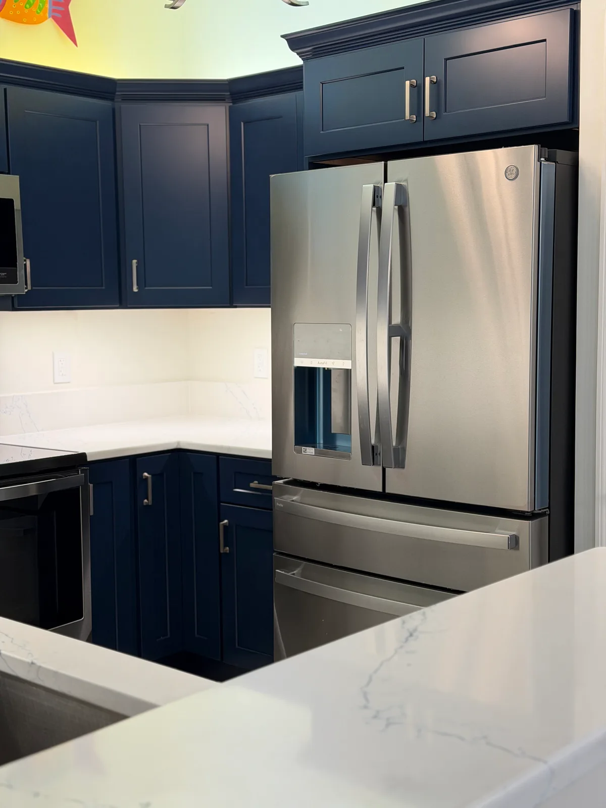 Navy shaker cabinetry beside a stainless french-door refrigerator, Bonita Springs