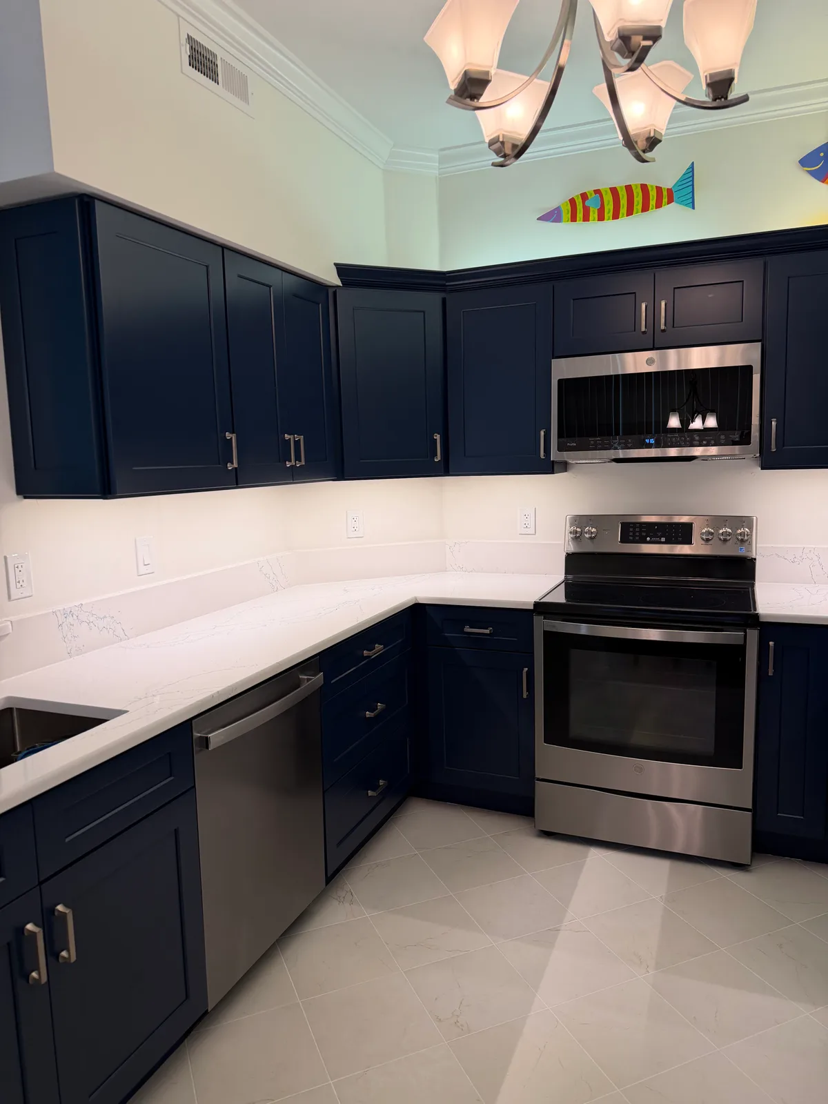 Navy shaker kitchen with white quartz counters and a stainless range — Bonita Springs kitchen remodel