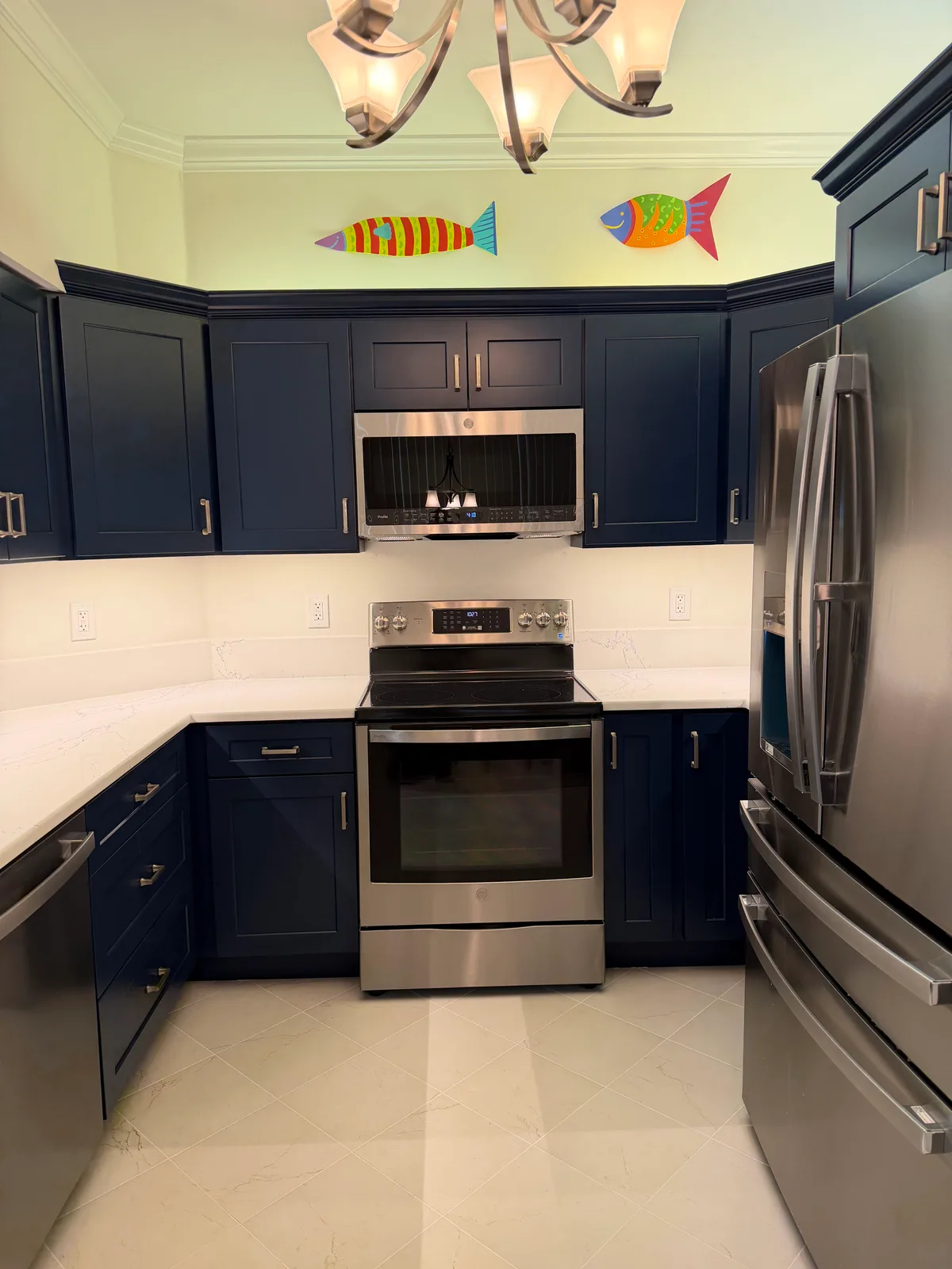 Navy shaker kitchen with stainless appliances and large-format tile flooring