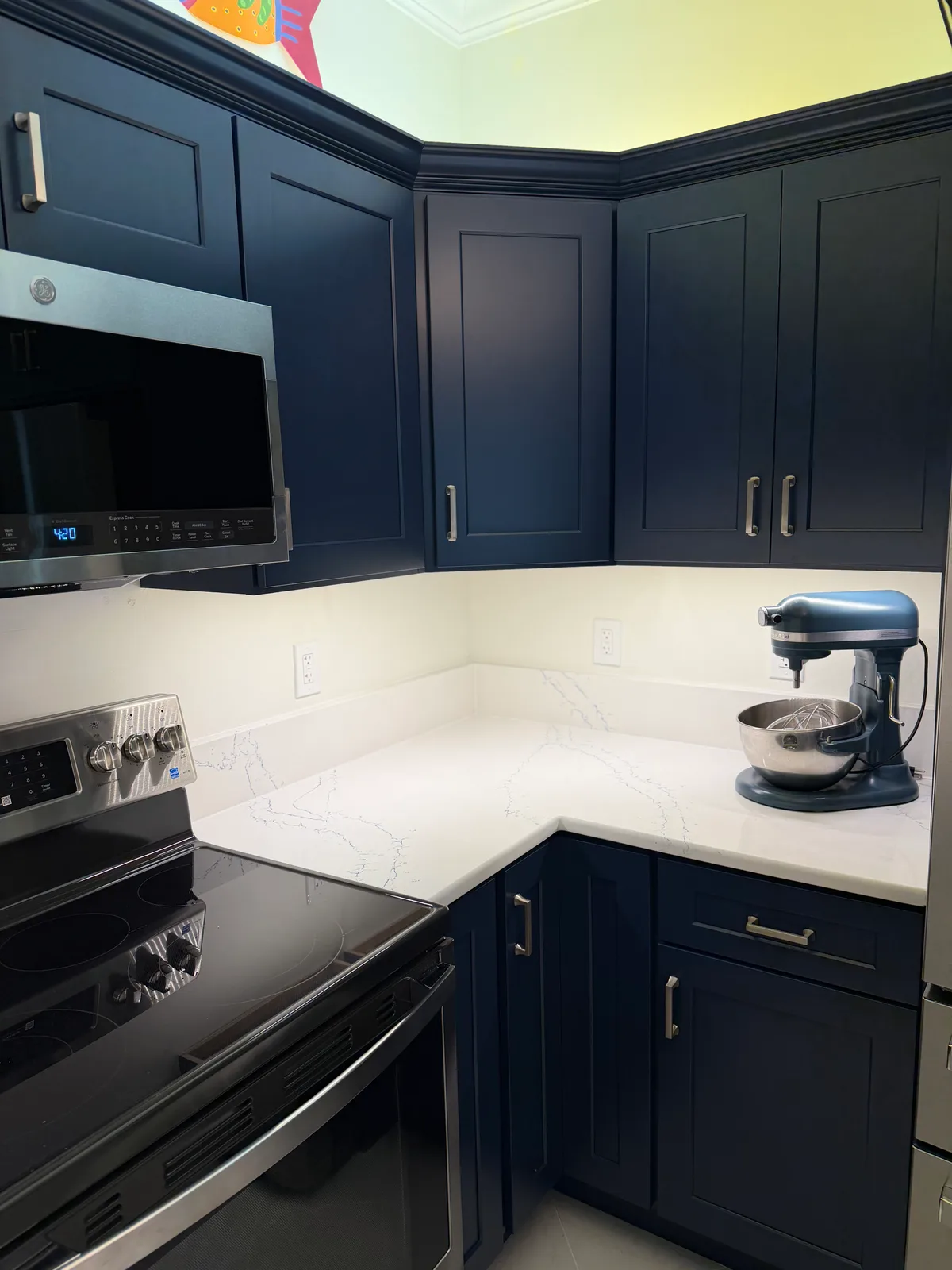 Navy shaker upper cabinets above a white quartz counter, Bonita Springs kitchen