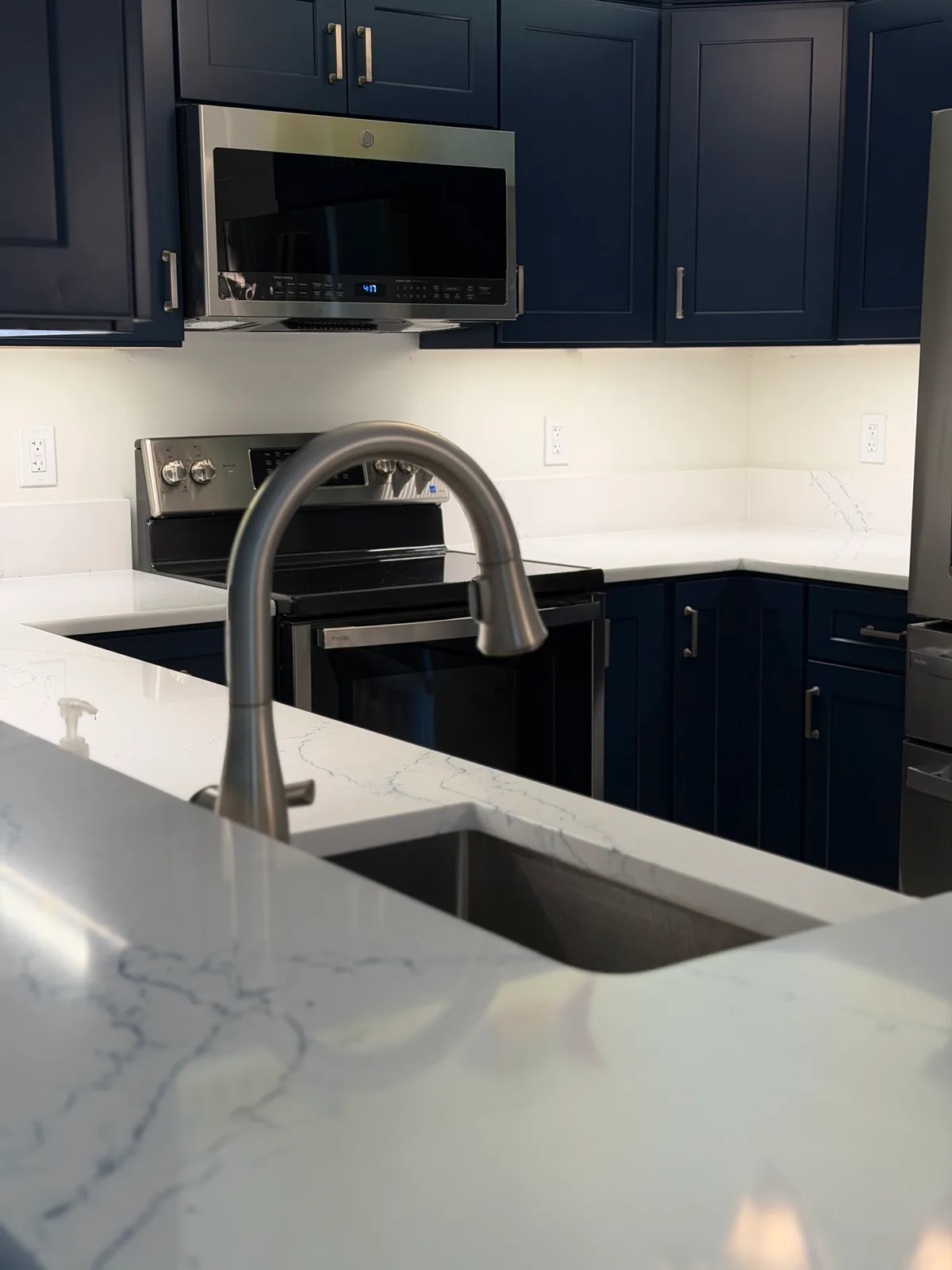 White quartz counter with undermount sink and brushed gooseneck faucet, Bonita Springs kitchen