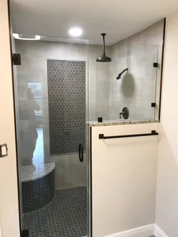 Black hex tile shower accent wall with matte black rain head