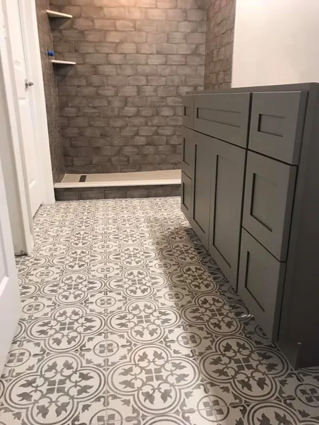 Brick-look tile shower with patterned cement floor tile and gray vanity
