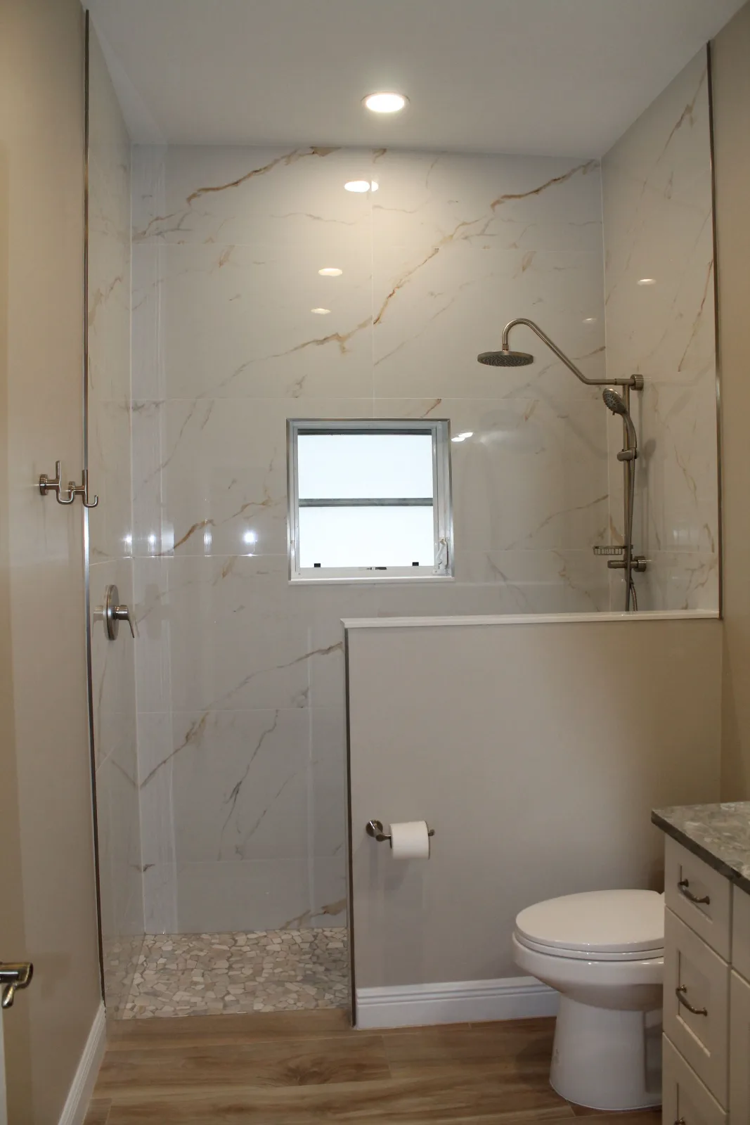 Tub-to-shower conversion in marble-look porcelain with a shower window
