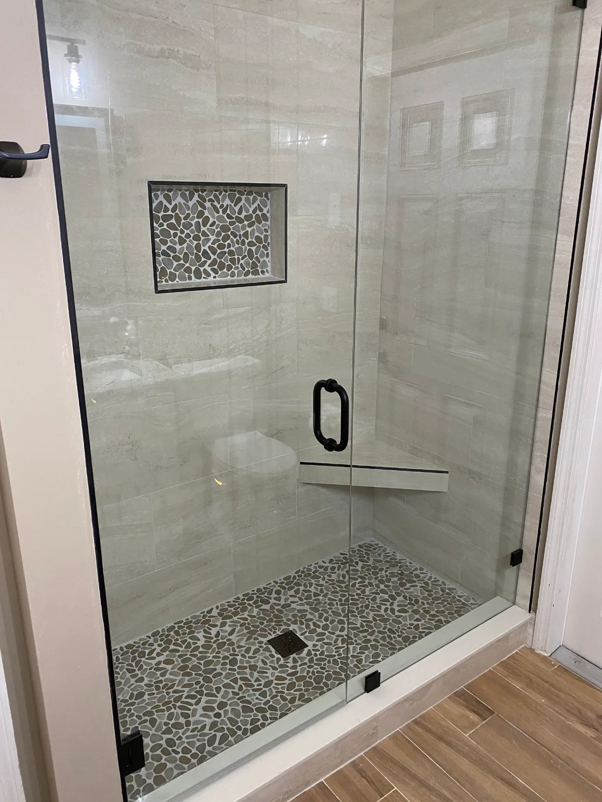 Walk-in shower with mosaic-lined niche and pebble mosaic pan