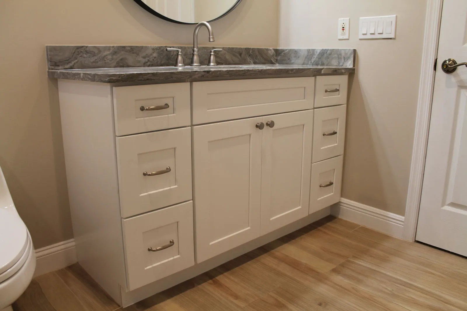White shaker vanity with a granite counter and brushed nickel hardware