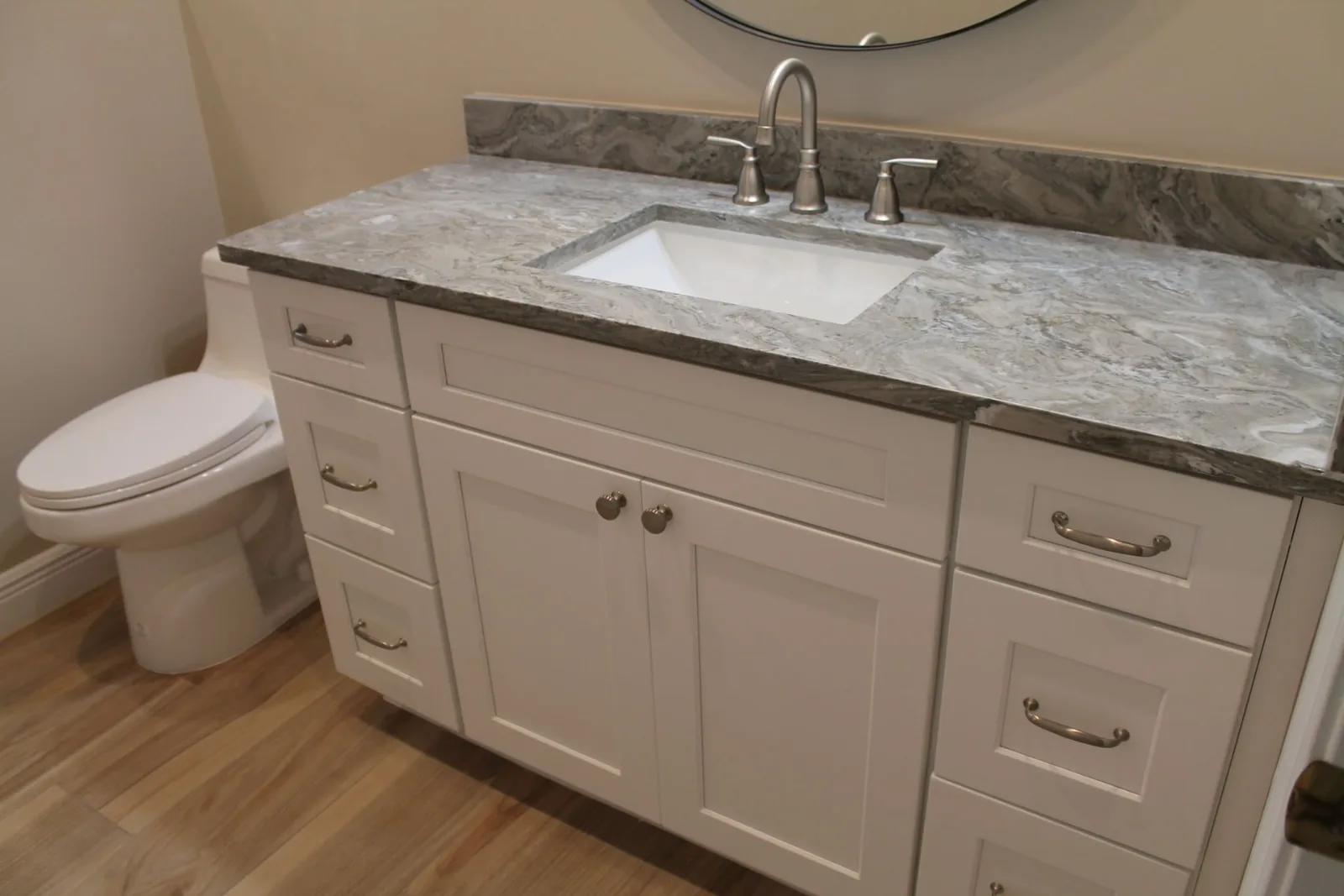 White shaker vanity with a granite top and undermount sink