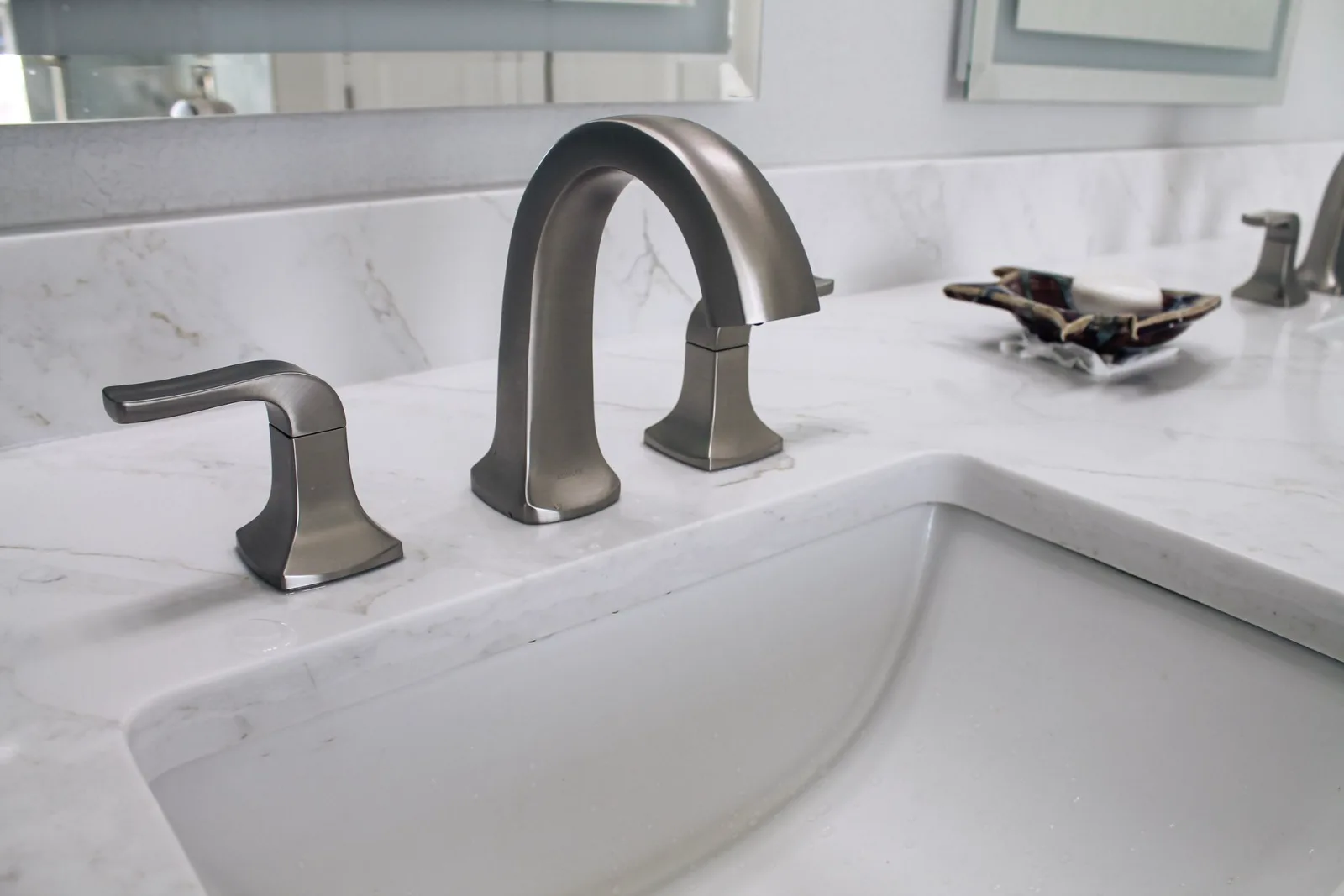 Brushed nickel widespread faucet on a quartz vanity with undermount sink