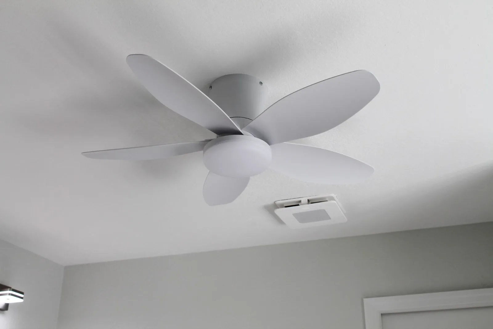 White ceiling fan and bath ventilation fan installed in a remodeled bathroom
