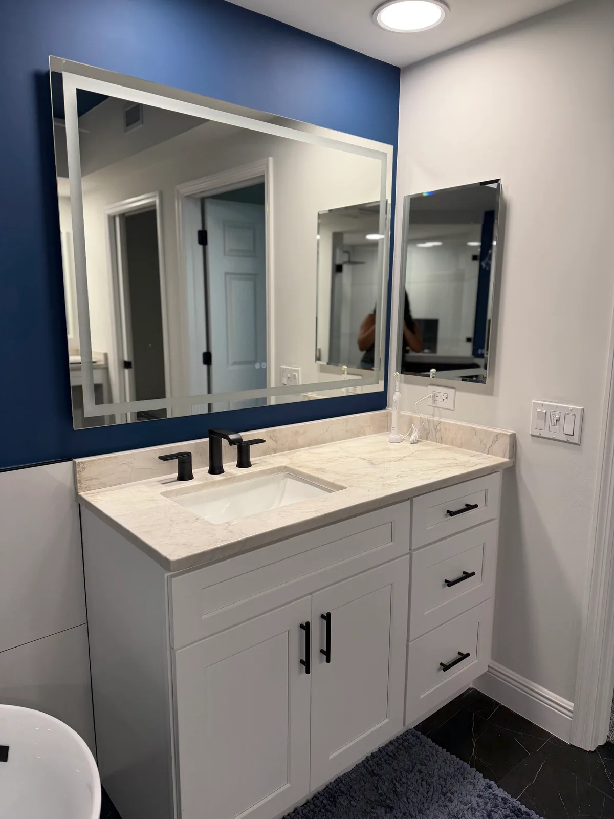Vanity with white-framed mirrors against a navy painted wall, Naples