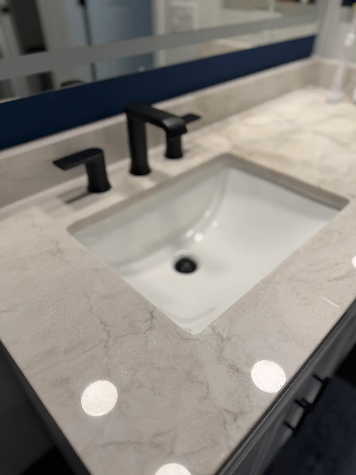 Undermount rectangular sink set into a veined quartz vanity top