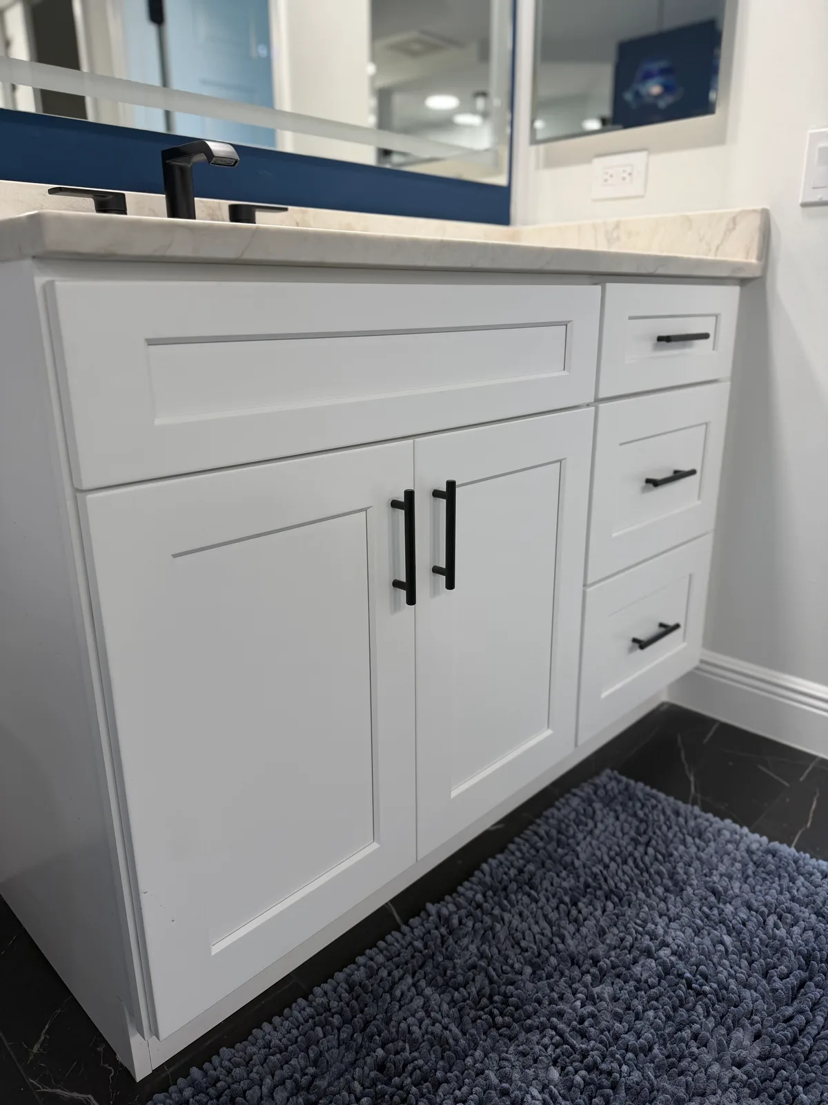 White shaker vanity cabinetry with matte black bar pulls in a Naples master bath