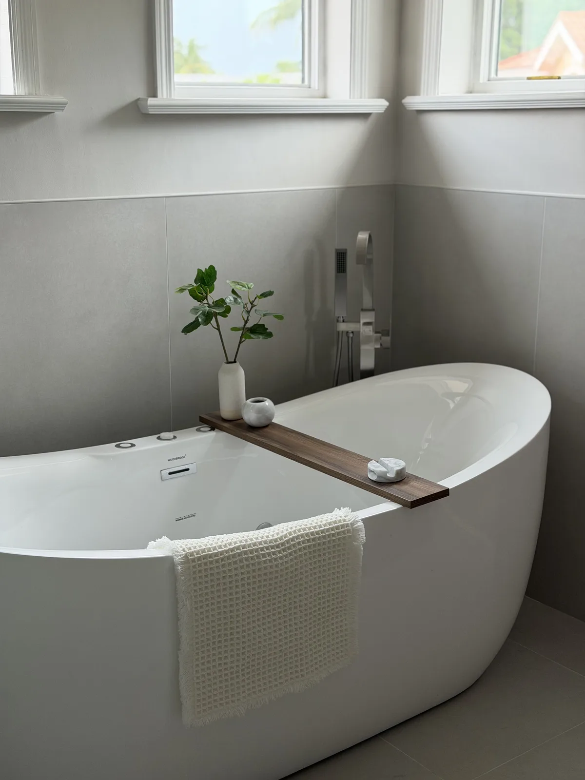 Freestanding soaking tub with a teak bath tray, Fort Myers master bathroom