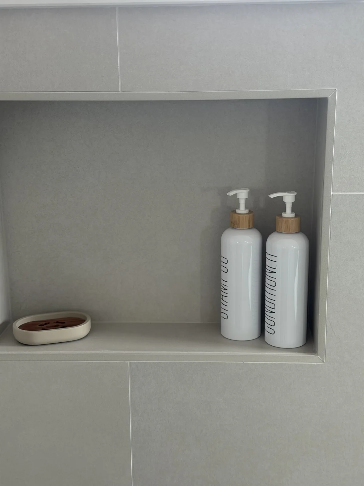 Recessed shower niche framed in greige large-format tile, Fort Myers