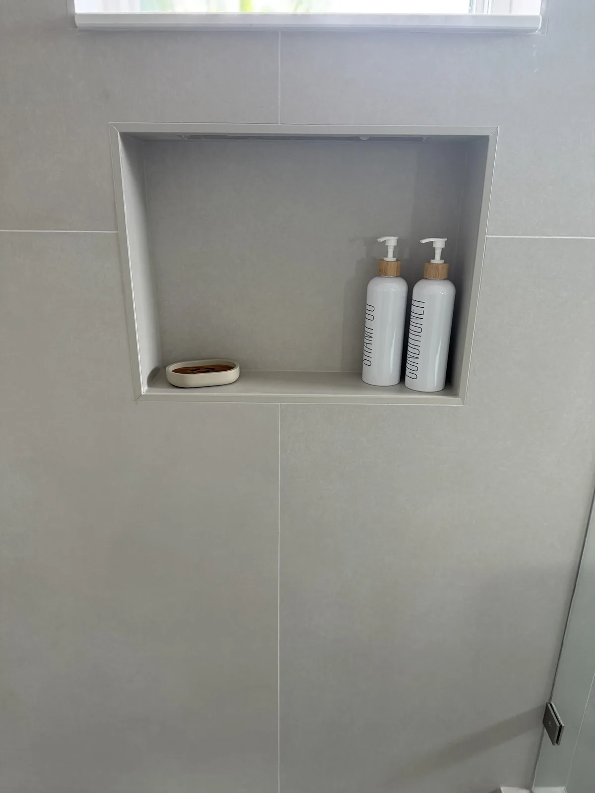 Shower niche with a soap ledge in greige large-format tile