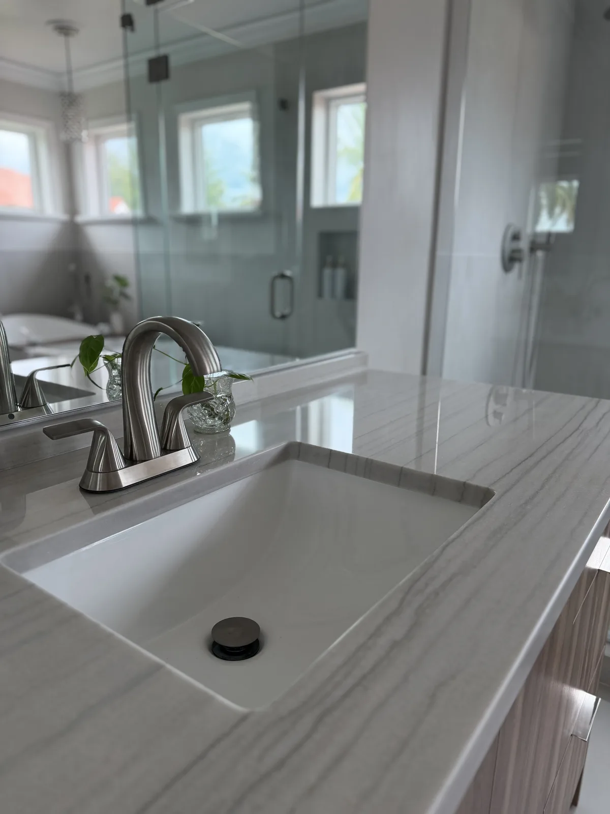 Undermount sink set into a quartz vanity top with brushed nickel fittings