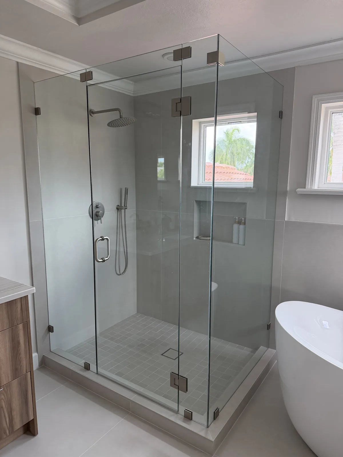 Walk-in shower and freestanding tub below awning windows, Fort Myers master bath