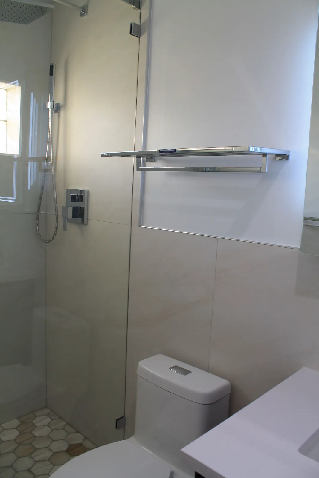 Frameless glass walk-in shower in a remodeled guest bathroom