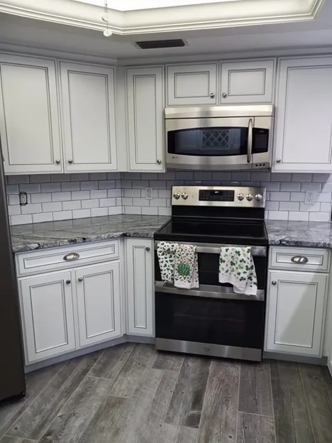 White kitchen cabinets with subway tile backsplash and stainless appliances