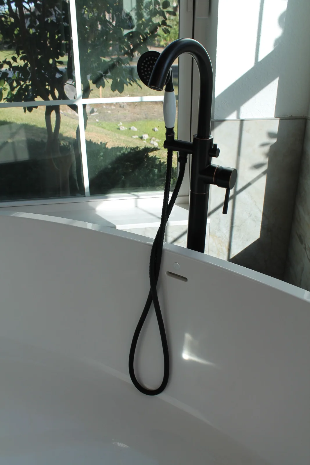 Oil-rubbed bronze freestanding tub filler with handheld sprayer