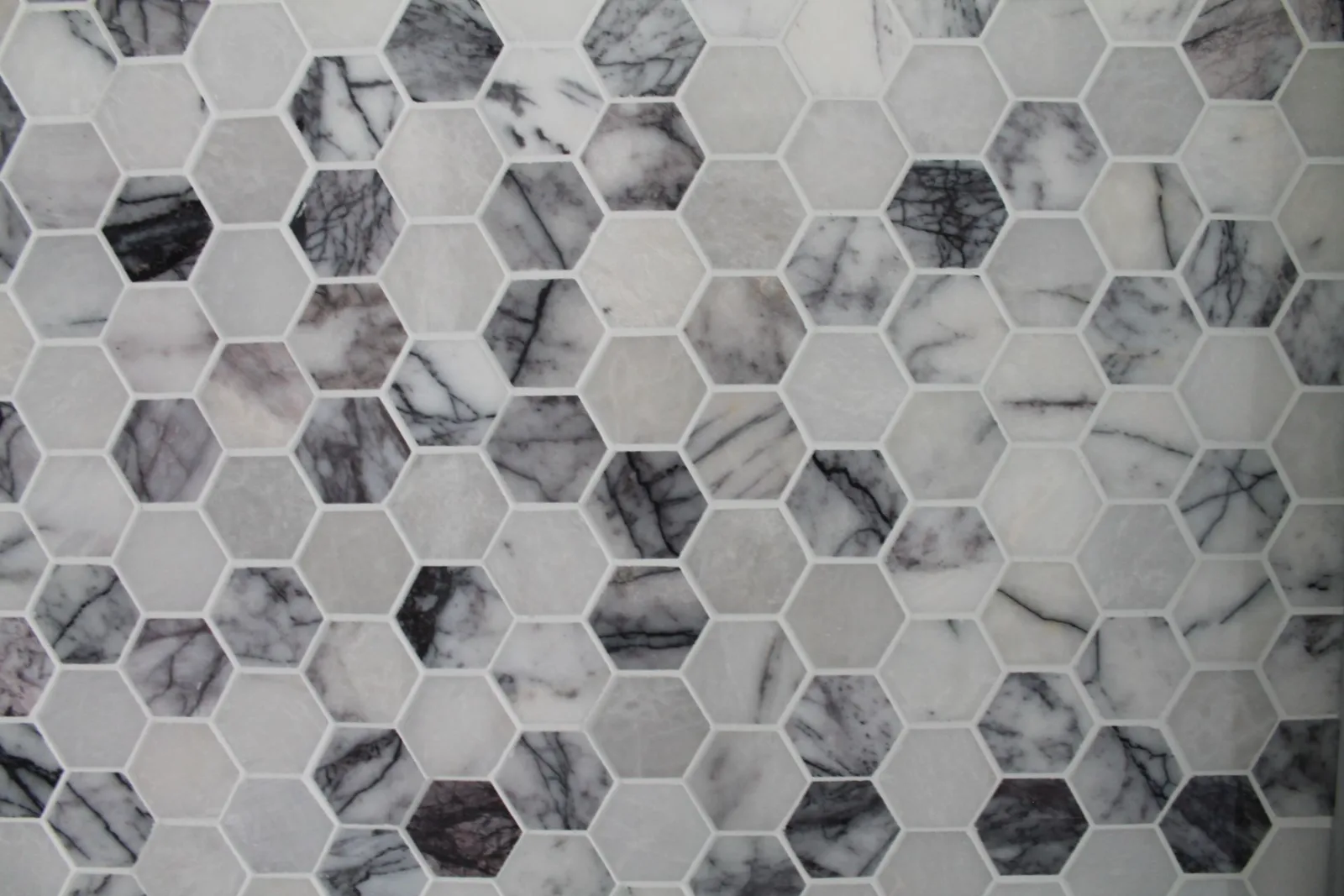Hand-laid marble hexagon mosaic tile with tight grout joints