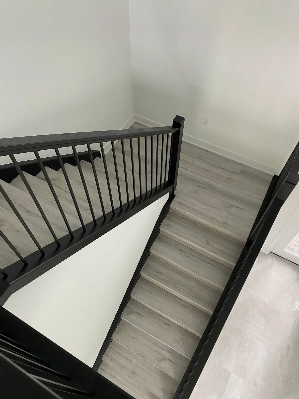 Second floor landing in luxury vinyl plank with black metal railing