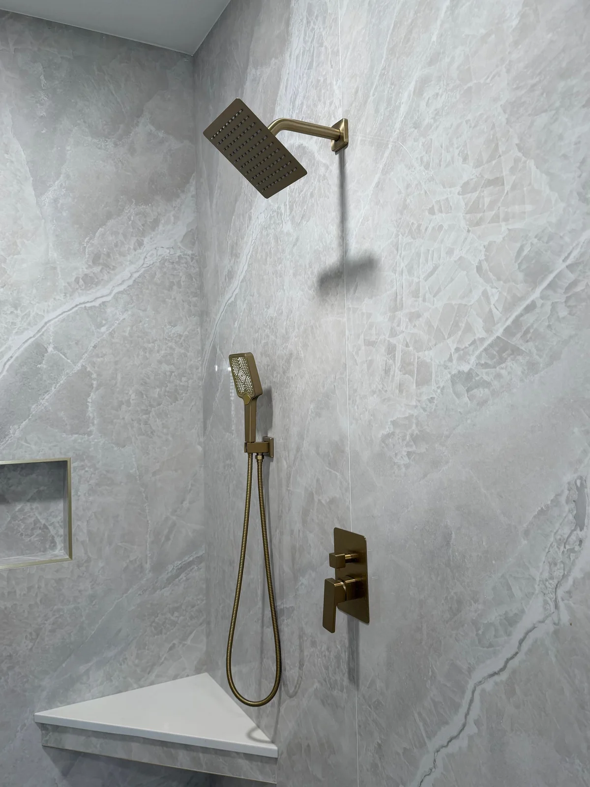 Quartzite-look porcelain tile shower with brushed gold fittings — Southwest Florida